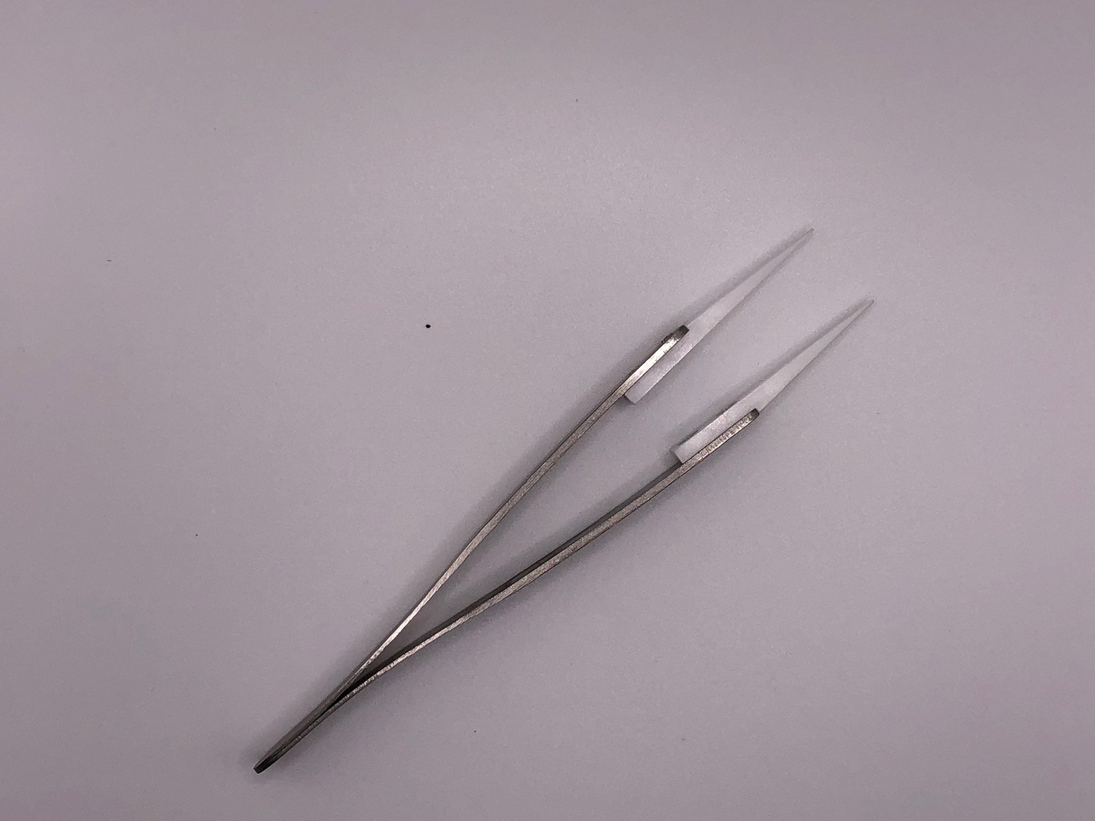 Fine-point ceramic tipped stainless steel tweezers for precise, heat-resistant handling of small model railway parts and electronics.