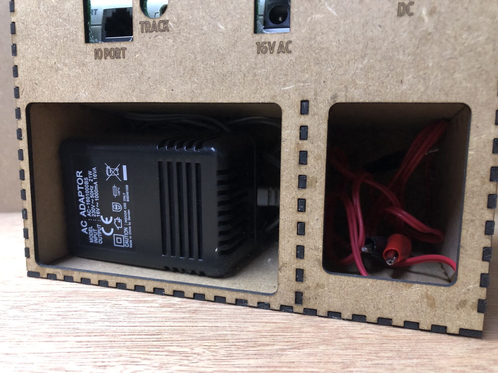 Desktop stand and tidy kit holding a Bachmann EZ DCC model railway controller with space beneath for power brick and leads