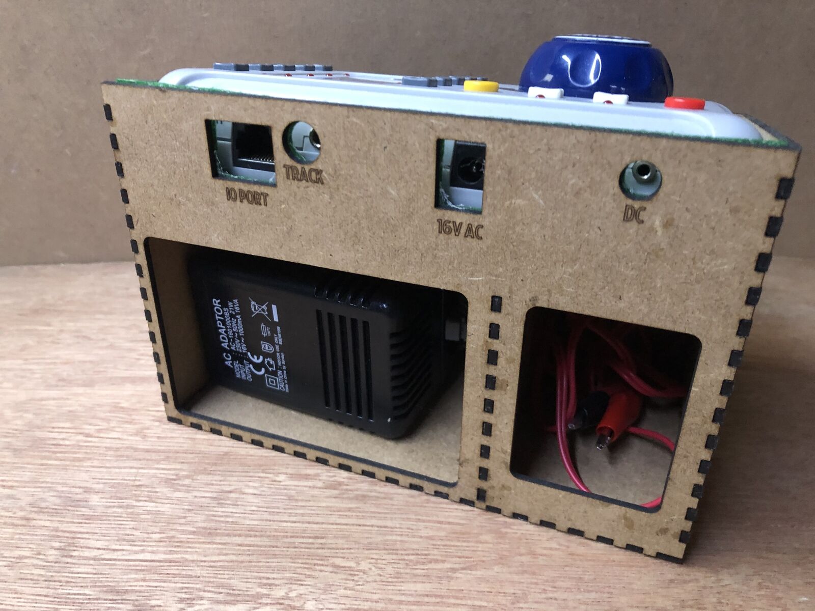 Desktop stand and tidy kit holding a Bachmann EZ DCC model railway controller with space beneath for power brick and leads