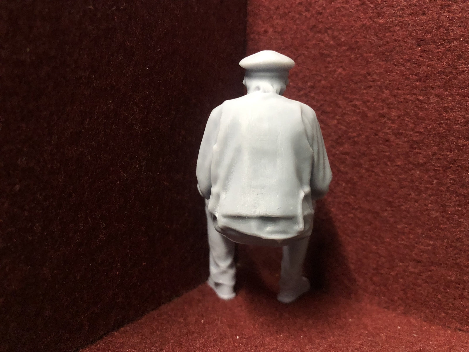 Unpainted 16mm 1:19 scale seated male figure in cap for SM32 garden railway layouts, suitable as a driver or resting passenger