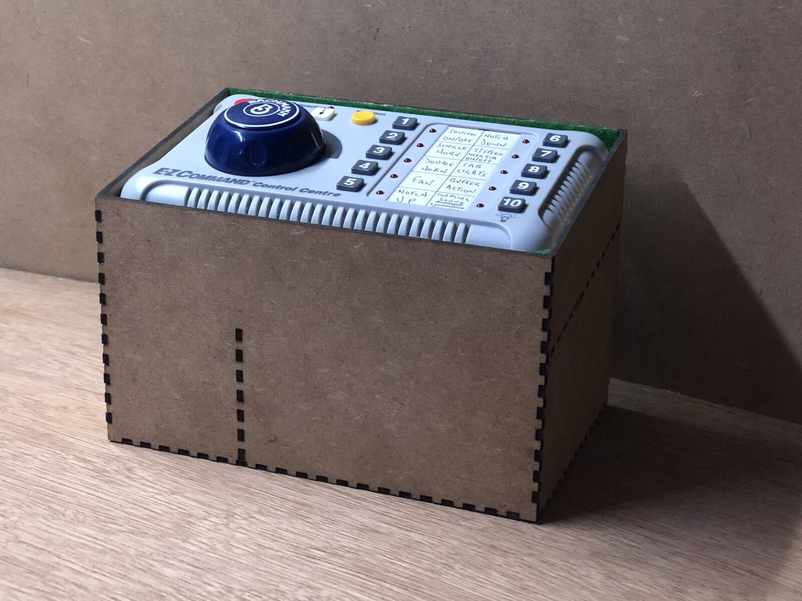 Desktop stand and tidy kit holding a Bachmann EZ DCC model railway controller with space beneath for power brick and leads