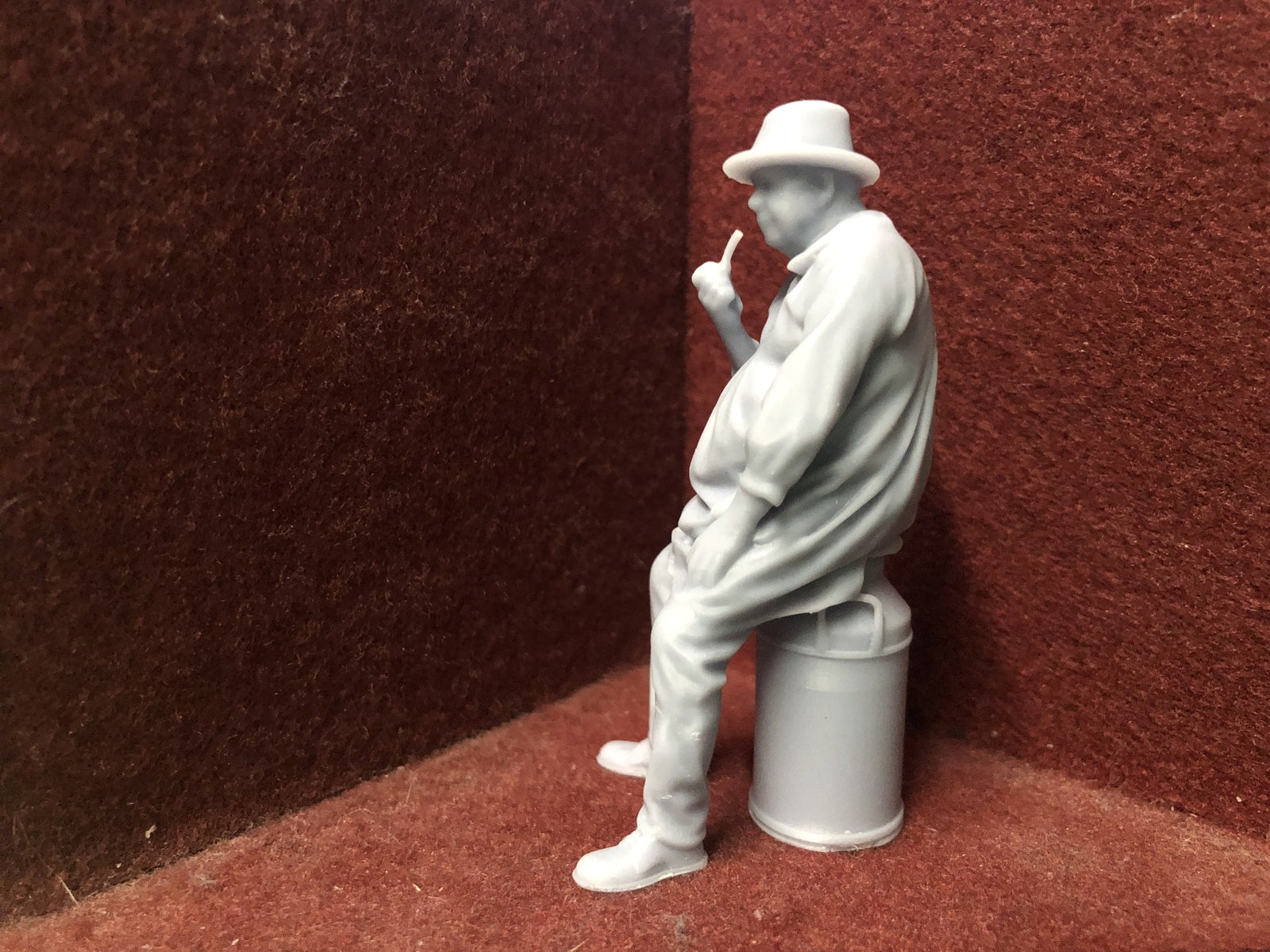 Unpainted G-scale 1:22.5 farmer figure sitting on a milk churn model railway accessory, suitable for G and GN15 layouts