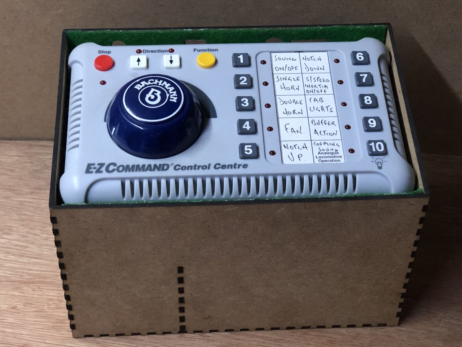 Desktop stand and tidy kit holding a Bachmann EZ DCC controller, with space beneath for power brick and leads on a model railway desk