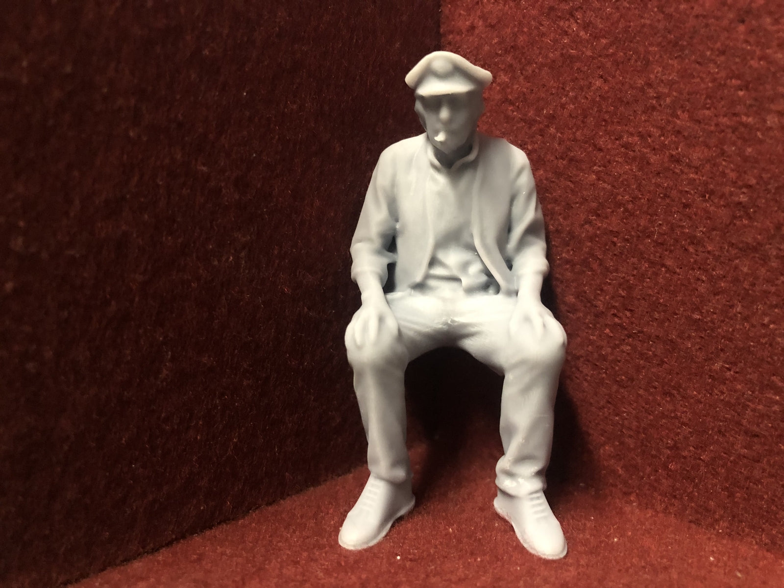 Unpainted 16mm 1:19 scale seated male figure in cap for SM32 garden railway layouts