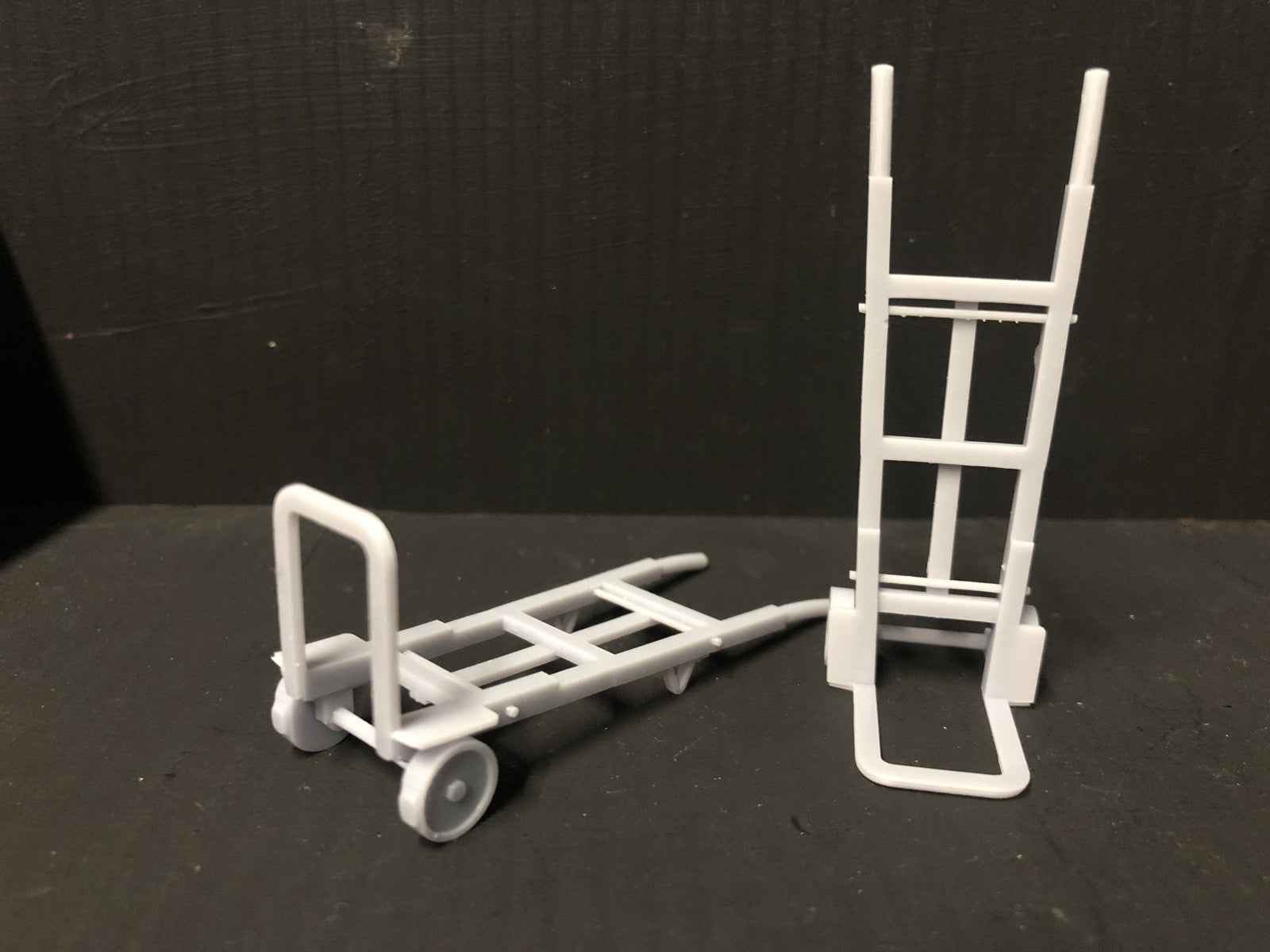 Unpainted GN15 G scale pair of resin sack trolleys for model railway platforms or workshops, shown in grey ready for detailing