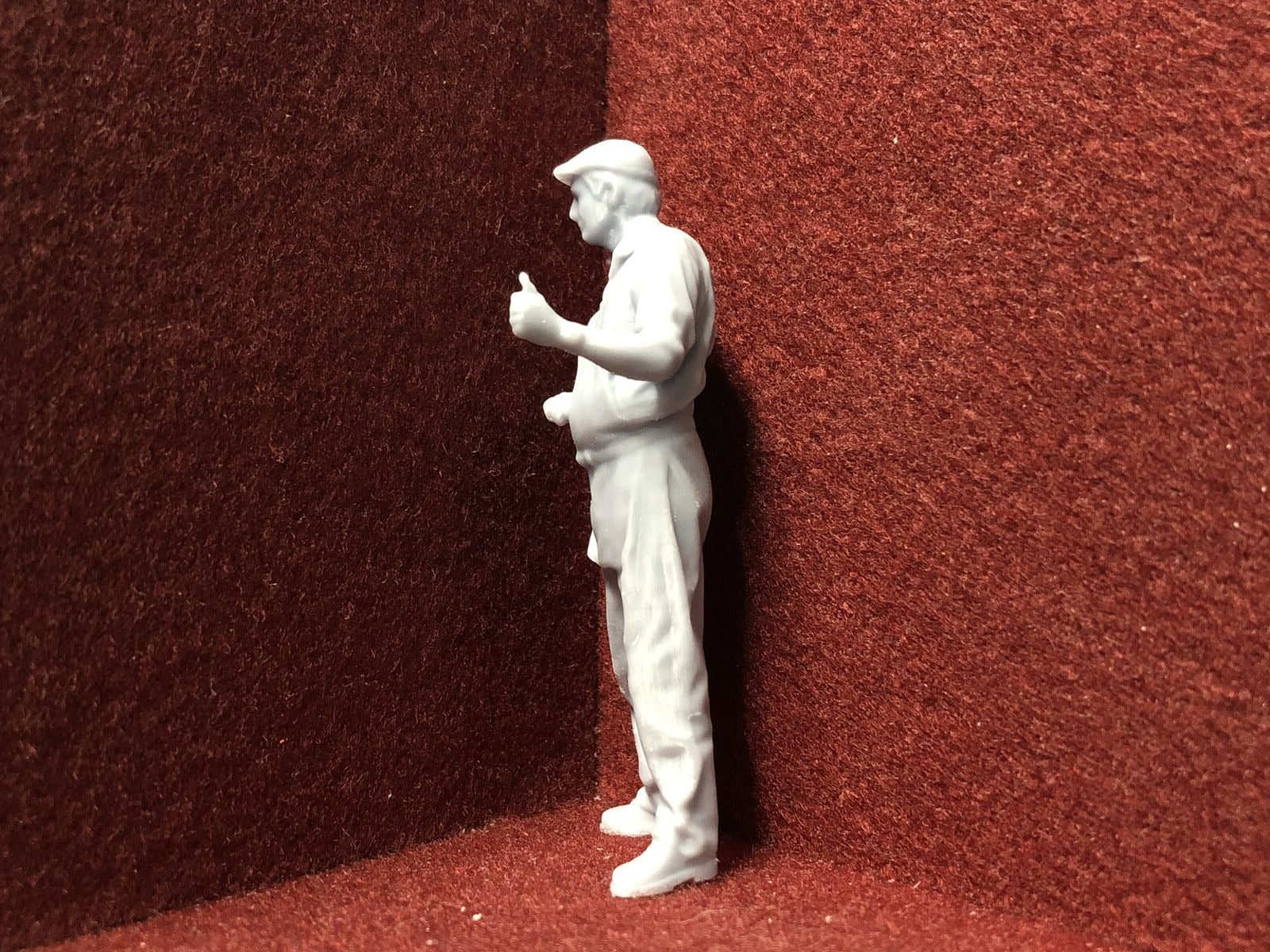 Unpainted G-scale 1:22 driver figure with flat cap giving thumbs up, suitable for GN15 narrow gauge model railway layouts