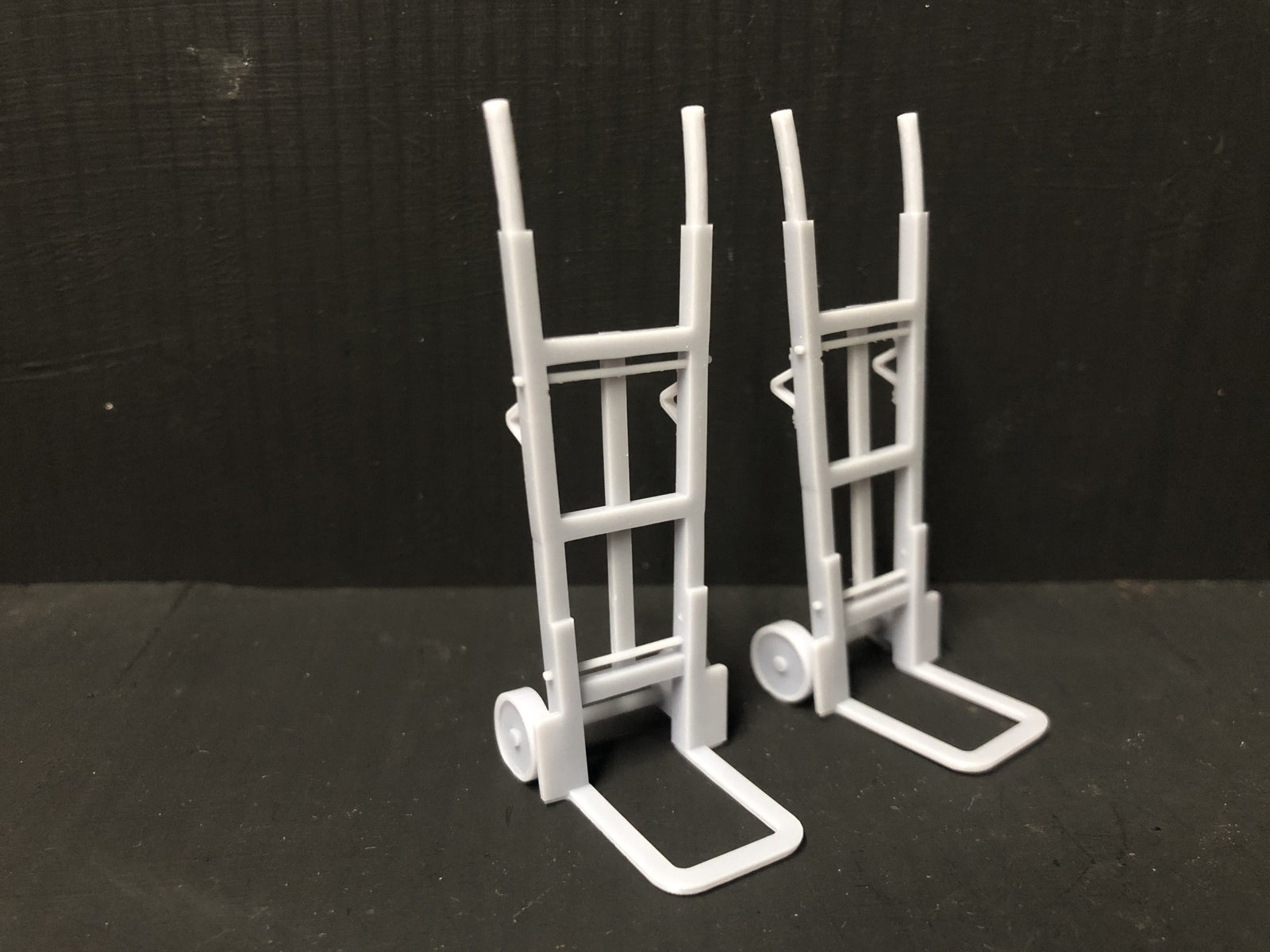 Unpainted GN15 G scale pair of resin sack trolleys for model railway platforms or workshops, shown in grey ready for detailing