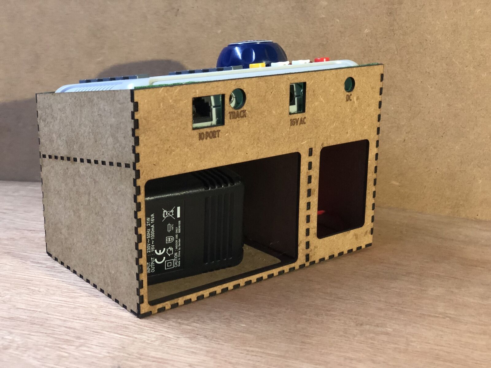 Desktop stand and tidy kit holding a Bachmann EZ DCC model railway controller with space beneath for power brick and leads