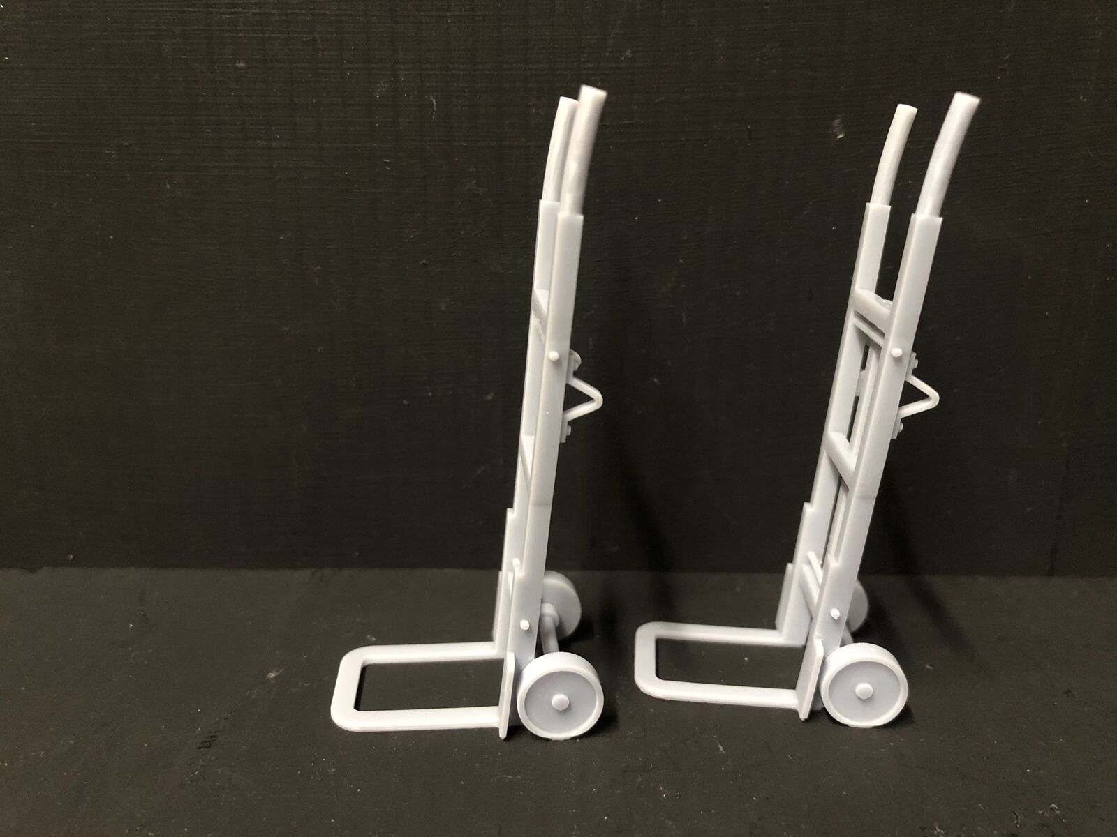 Unpainted 16mm scale resin model sack trolleys for railway platforms or workshop scenes, supplied as two detailed grey pieces