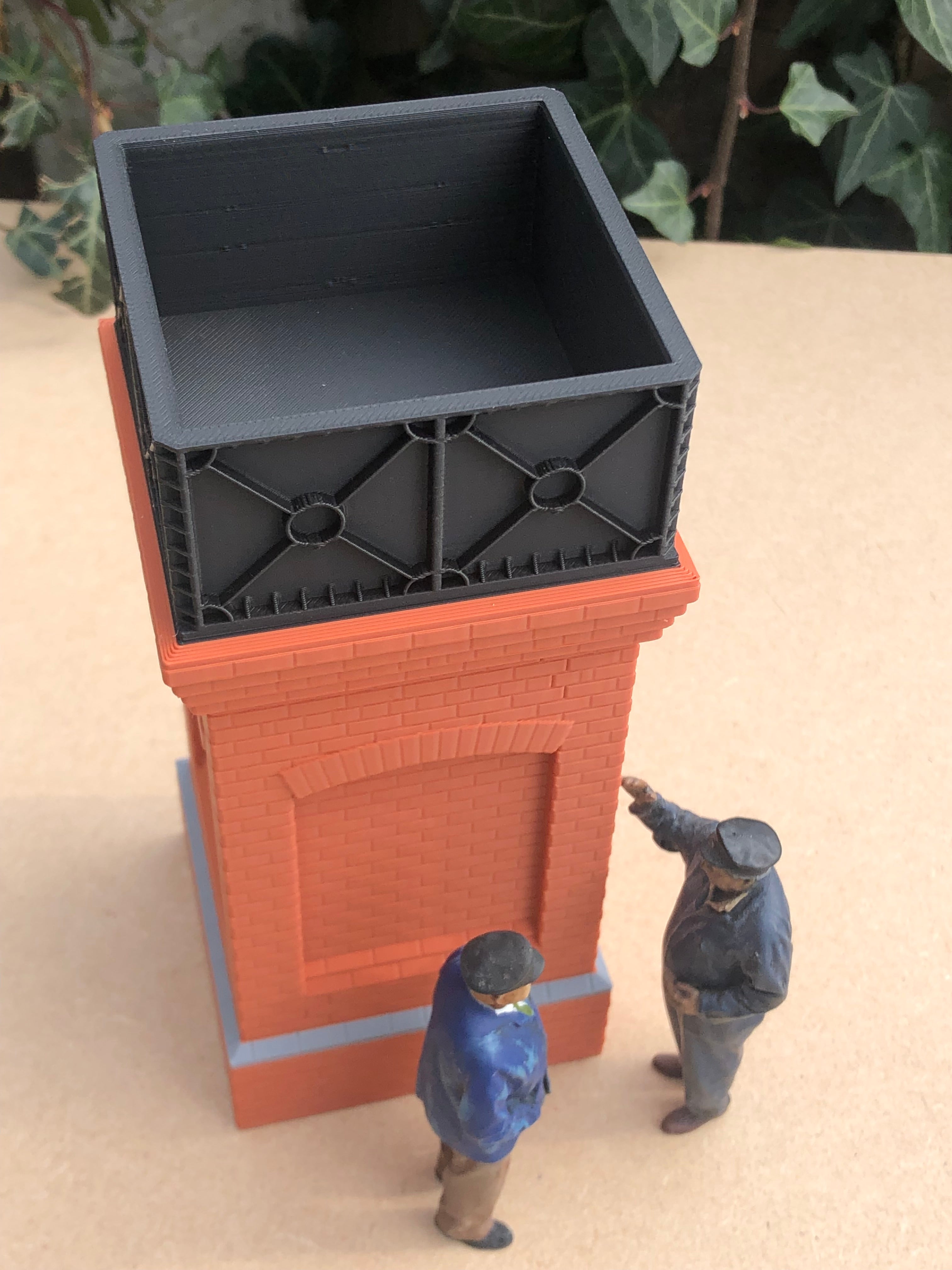 Unpainted but pre-coloured small brick water tower model for G Gauge or GN15 layouts, 3D printed in brick, grey and black PLA