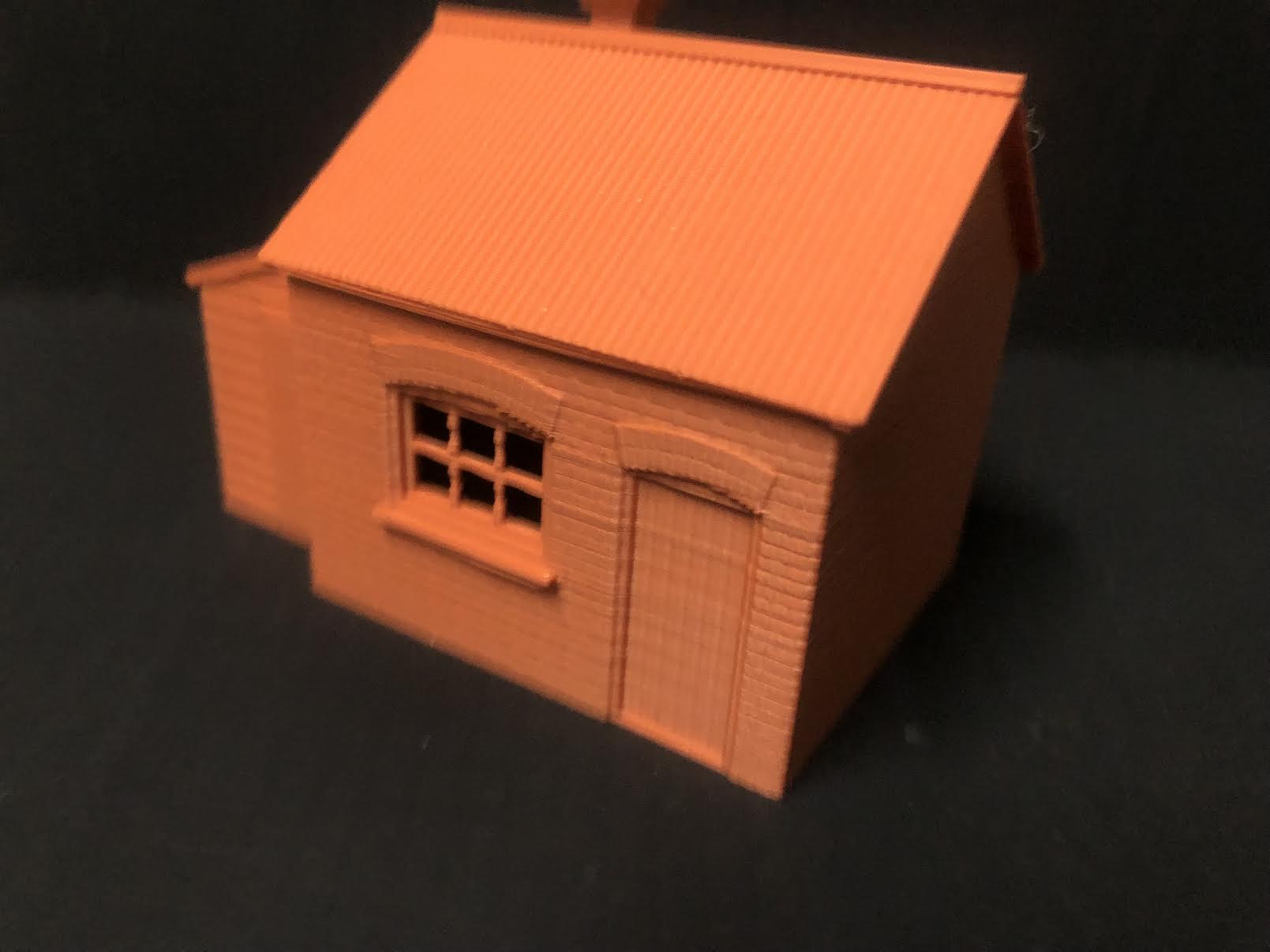 Unpainted OO9 scale brick workshop with lean-to resin building, featuring corrugated steel effect walls and roof for model rail layouts