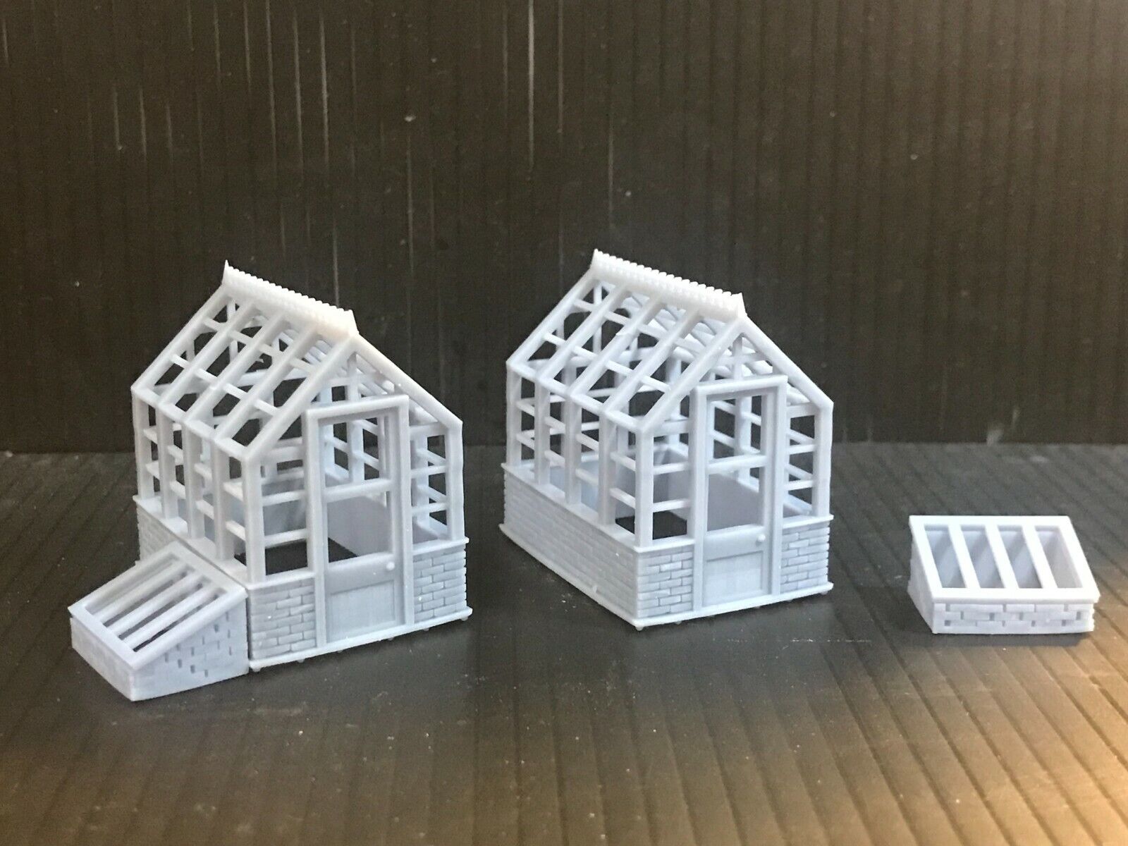 Unpainted 00 gauge resin kit with two Victorian-style greenhouses and two cold frames for model railway garden scenes