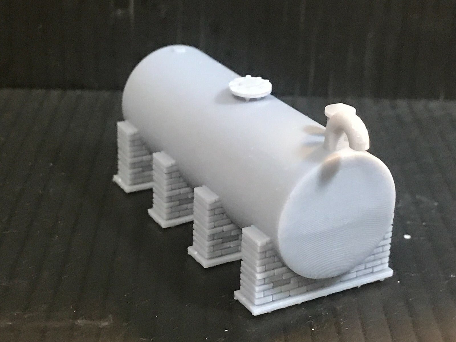 Unpainted OO/HO/OO9 gauge single diesel depot tank on brick supports model kit, ready for priming and painting.