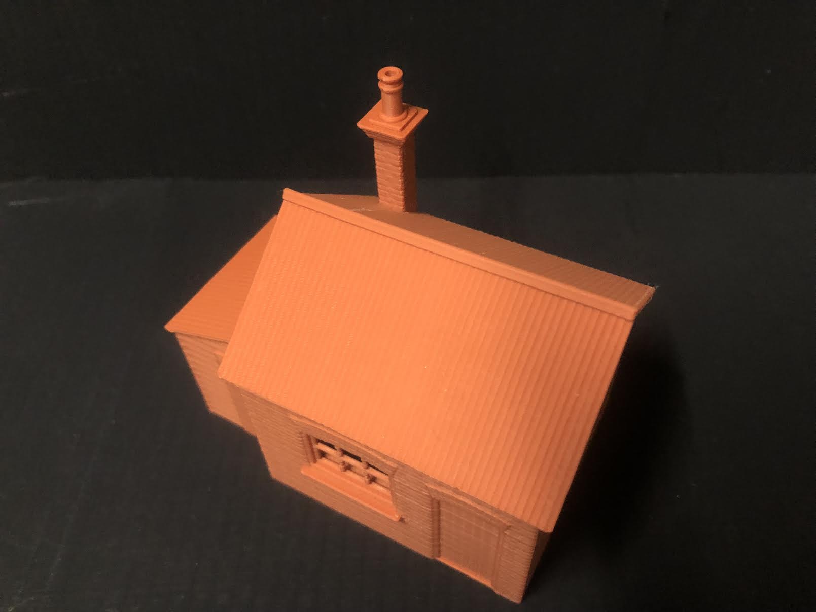 Unpainted OO9 scale brick workshop with lean-to resin building, featuring corrugated walls and roof for model railway layouts