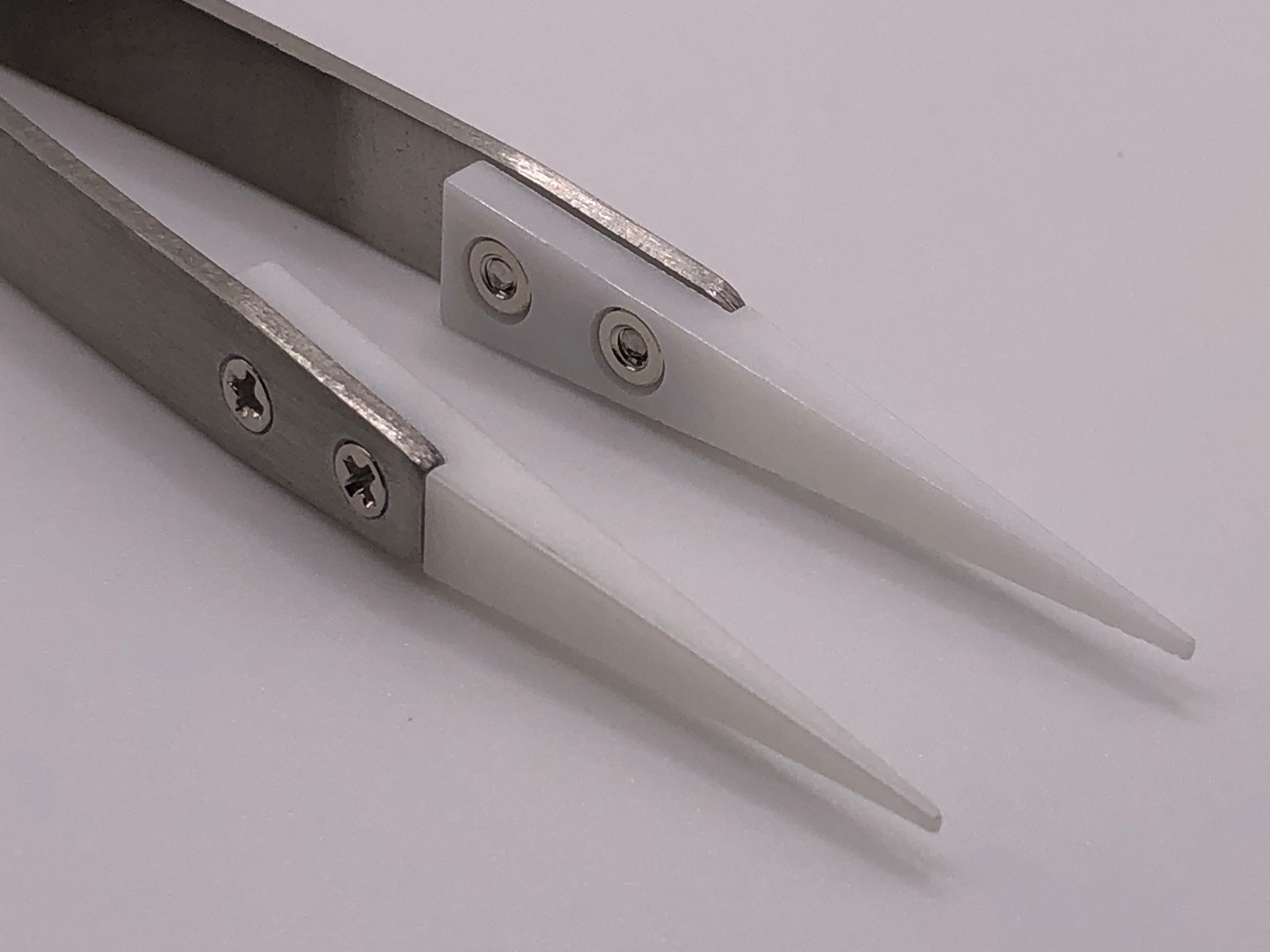 Fine-point stainless steel tweezers with white ceramic heat-resistant tips, ideal for precise model railway detailing work
