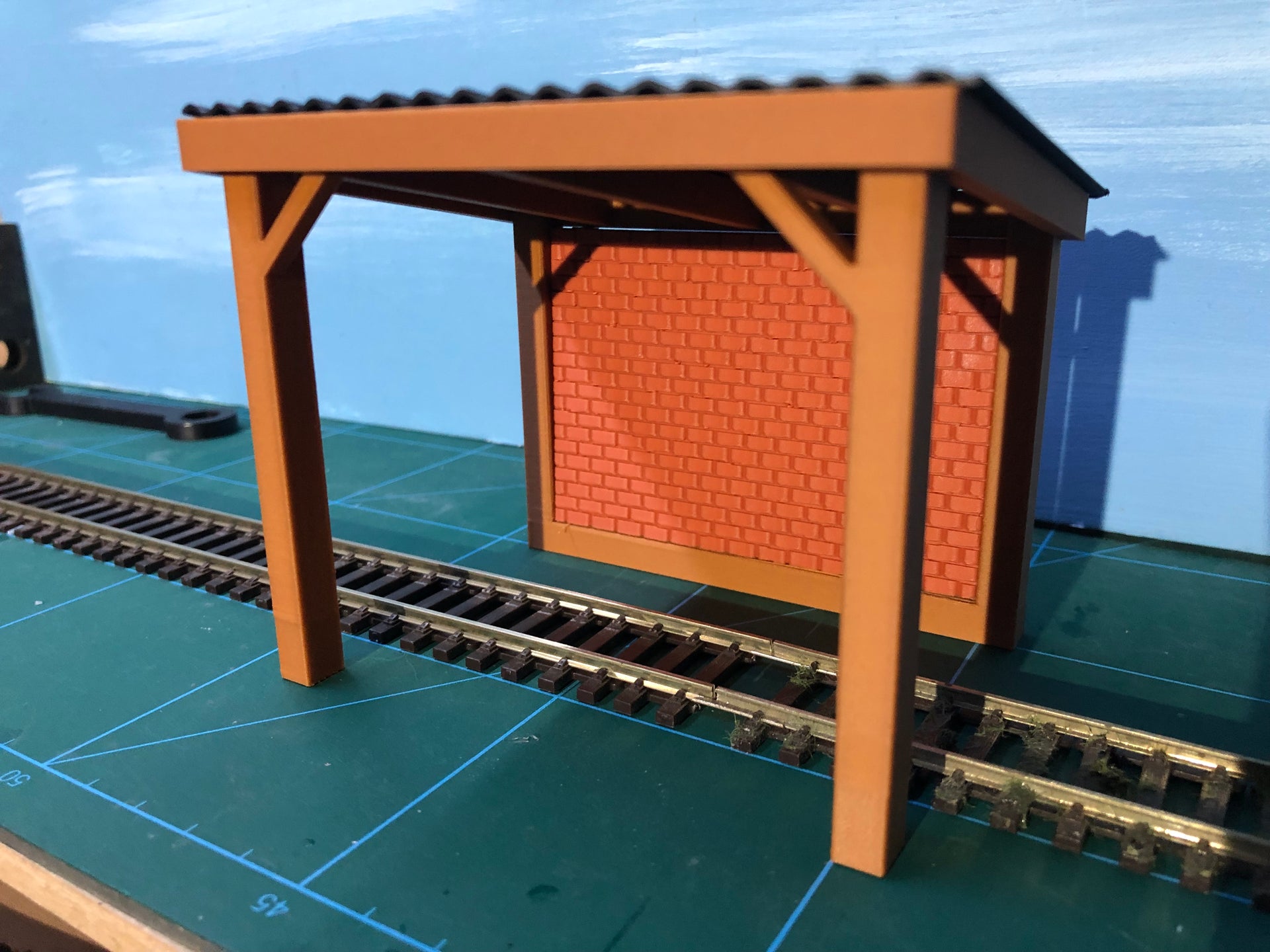 NG7 7mm scale engine stand model with corrugated roof, wooden sides and brick rear wall for ON30 narrow gauge layouts