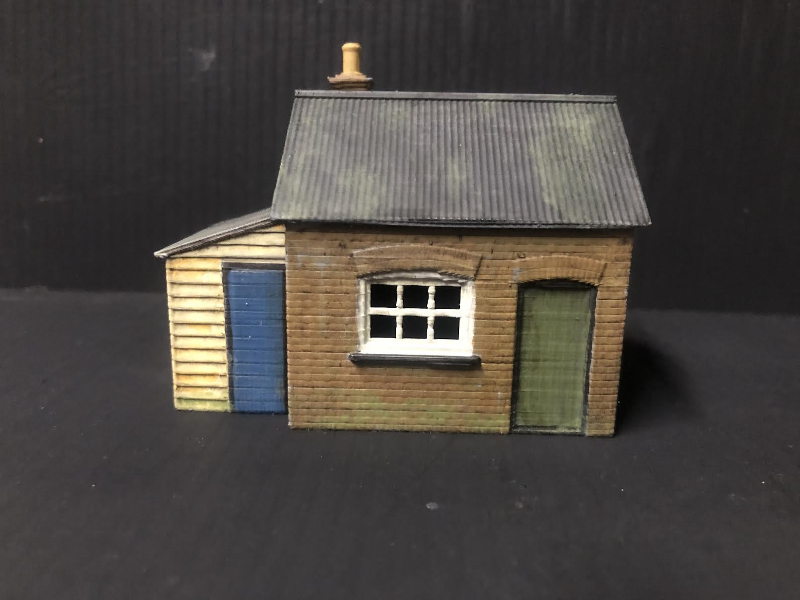 Unpainted OO9 scale brick workshop with lean-to, resin model railway building with corrugated walls and roof for layout detailing