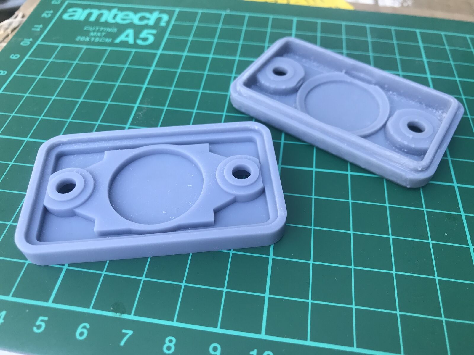 Covert Apple AirTag case disguised as a small black plastic block for hidden tracking on a car, motorbike or boat