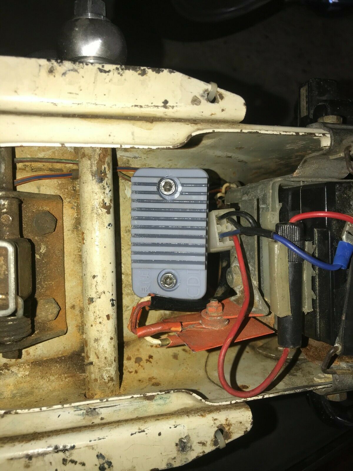 Black stealth covert case for an Apple AirTag, shown mounted for discreet use on a car or motorbike