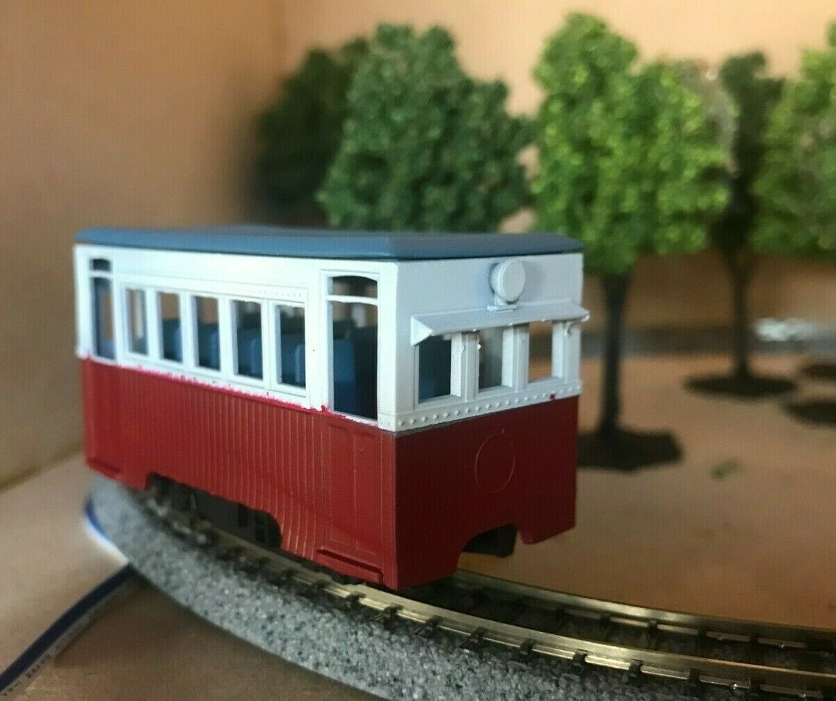 Unpainted OO9 narrow gauge prototype railbus body, roof and interior kit shown on a compatible Kato 103/109/105 chassis